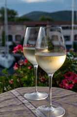 Tasting of local white wine in summer with sail boats haven of Port Grimaud on background, Provence, France