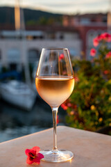 Tasting of local rose wine in summer with sail boats haven of Port Grimaud on background, Provence, France
