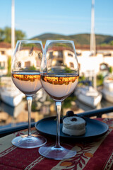 Tasting of local rose wine and soft french goat cheese in summer with sail boats haven of Port Grimaud on background, Provence, France