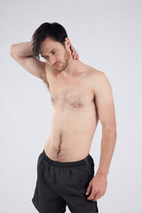 Handsome man with no shirt on looking thoughtful.