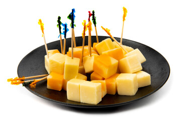 a black plate of orange marble and white cheddar cheese cube appetizers with fancy toothpicks isolated on white