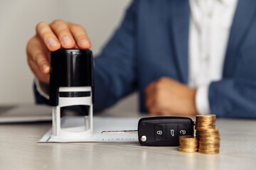 Car salesman sitting in office stamping contract, concept for sale car, insurance with car.