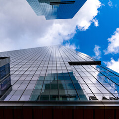 Fototapeta na wymiar looking up at blue sky through glass building