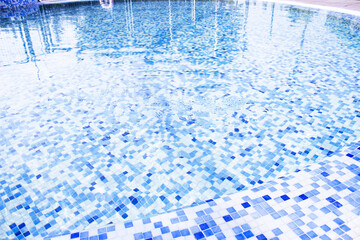 Circular pool with mosaic background in blue tones