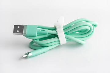 Green usb cable for charging a mobile phone on a white background. silicone mobile phone accessory