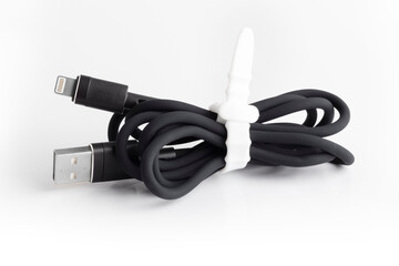Black usb cable for charging a mobile phone on a white background. silicone mobile phone accessory