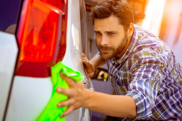 Fototapeta premium A man cleaning car with microfiber cloth.