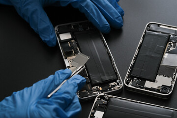 Technician repairing the Cell phone parts and tools for recovery repair phone smartphone and upgrade mobile technology,the concept of computer hardware inside.