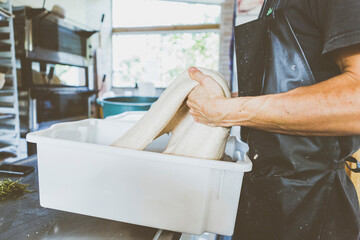 Close up of artisanal sourdough bread production on small bakery. New normal covid-19 economic recovery profession change storytelling concept.
