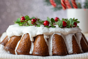 Christmas Stollen: a festive cake decorated with cranberries and twigs. Christmas decor on the table. Concept of greeting cards, banners, and holiday greetings.