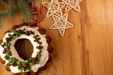 Christmas Stollen: a festive cake decorated with cranberries and twigs. Christmas decor on the table. Concept of greeting cards, banners, and holiday greetings.