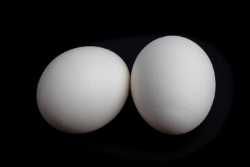 two white eggs isolated on a black background