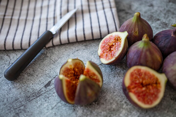 A few figs freely lying on old table. Fresh Organic Figs. Fresh purple fig fruit and slices in the...