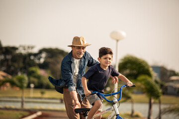 Avô ensinando neto andar de bicicleta