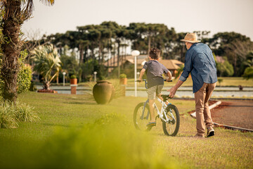 Avô ensinando neto andar de bicicleta