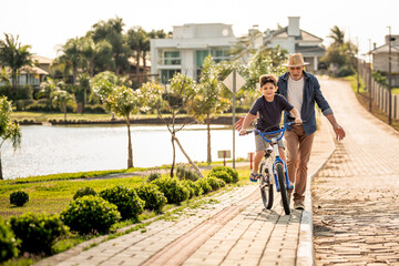 Avô ensinando neto andar de bicicleta