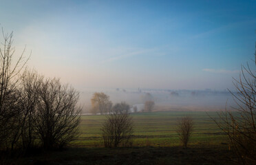 river  under morning fog in the field. river in the field under fog and clear sky.  foggy landscape 