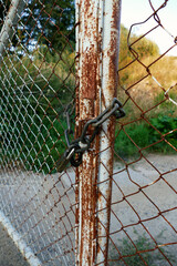 A rusty gate with a lock with a chain