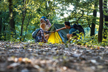 Young group of  people assembling tent in camp area. © BalanceFormCreative
