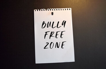 Paper note with BULLY FREE ZONE written on black slate board