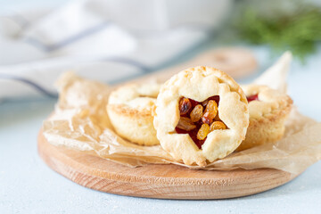 Christmas homemade mince pies on wooden paddle board on white background