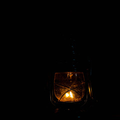 Vintage metal kerosene lamp lighting up a dark place with warm light.