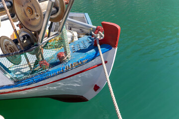 Colorful greek fishing boat and nets in a pier on Santorini, Greece.