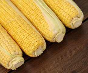 Close up shot fresh ripe and peeled sweet corn on wooden table. Grains of ripe corn.