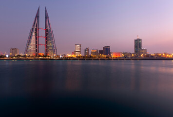 MANAMA, BAHRAIN - DECEMBER 19: The Bahrain World Trade Center at dusk, a twin tower complex is the first skyscraper in the world to have wind turbines, December 19, 2019 Manama, Bahrain