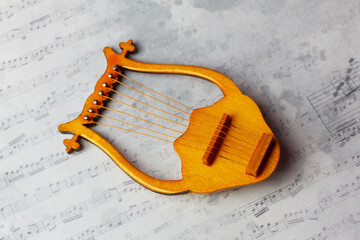 lyre - stringed plucked musical instrument on a musical background. A symbol of inspiration.