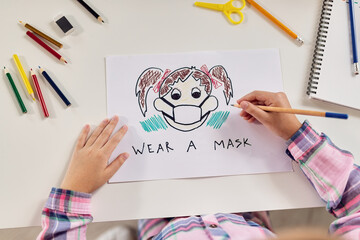 Close-up of child making coronavirus awareness drawings.