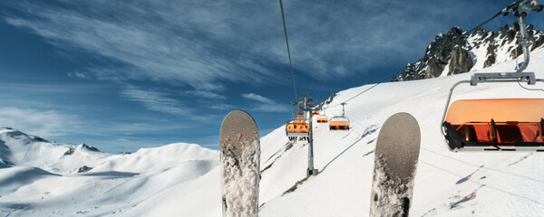 Scenic panoramic view of alpine peaks with ski lift ropeway on hilghland mountain winter resort and...