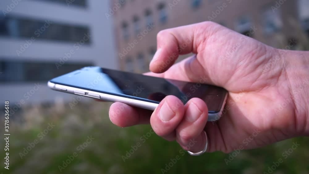 Poster close-up of a man using the phone in hand. scrolling and tapping the smartphone screen when sending 
