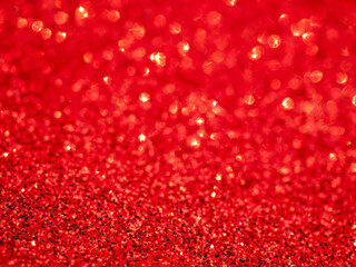 Red Festive Christmas background. Abstract twinkled bright background with bokeh defocused lights. Glister pattern. Brilliance backdrop. Holiday design.