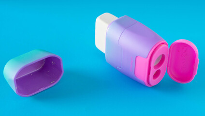 Eraser and pencil sharpener on blue background