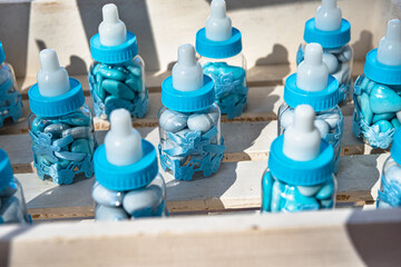 Close up photo of favor in the form of child bottles filled with candies for the guest attending the boy baptism