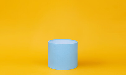 Blue round gift box on yellow background.