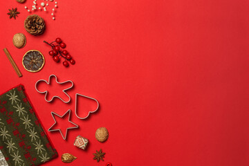 Layout for a new year or Christmas card on red paper, with cookie cutters, nuts and decorations for the Christmas tree. top with space