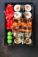 fresh sushi rolls salmon fish flying fish roe vegetables ginger wasabi rice and nori on the table serving size top view place copy space for text food background rustic
