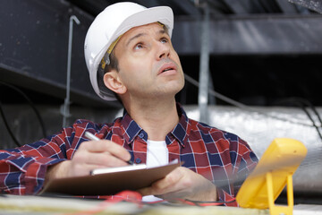 mature inspector looking around in the roof space