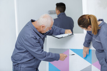 Obraz premium woman showing to a painter man where to paint