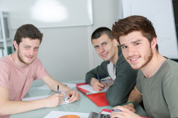 Obraz premium portrait of three male students sat at desk