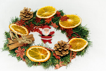 Christmas wreath on white isolated background. In the middle of the circle is a toy Santa Claus