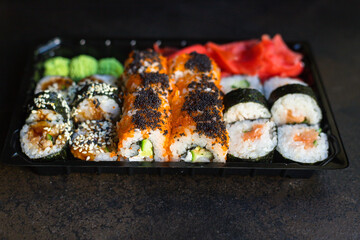 fresh sushi rolls salmon fish flying fish roe vegetables ginger wasabi rice and nori on the table serving size top view place copy space for text food background rustic