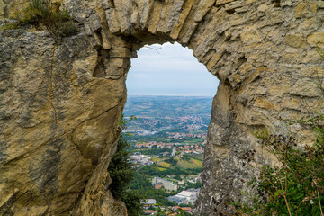 A view of towns in San Marino through a hole in the fortress wall