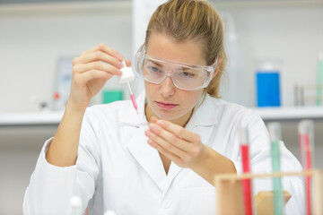 scientist pipetting solution into the glass test tube