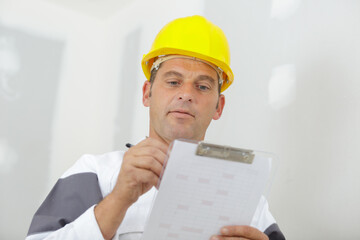 builder writing notes on clipboard