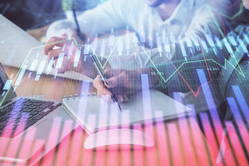 Double exposure of forex chart drawing over people taking notes background. Concept of financial analysis