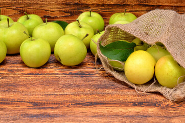 apples scattered from a bag on a wooden background