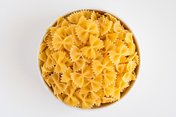 Raw dry uncooked Farfalle pasta spaghetti noodle on white bowl wooden background for basil tomato pesto sauce Homemade Italian food organic whole wheat vegan spaghetti for a healthy meal